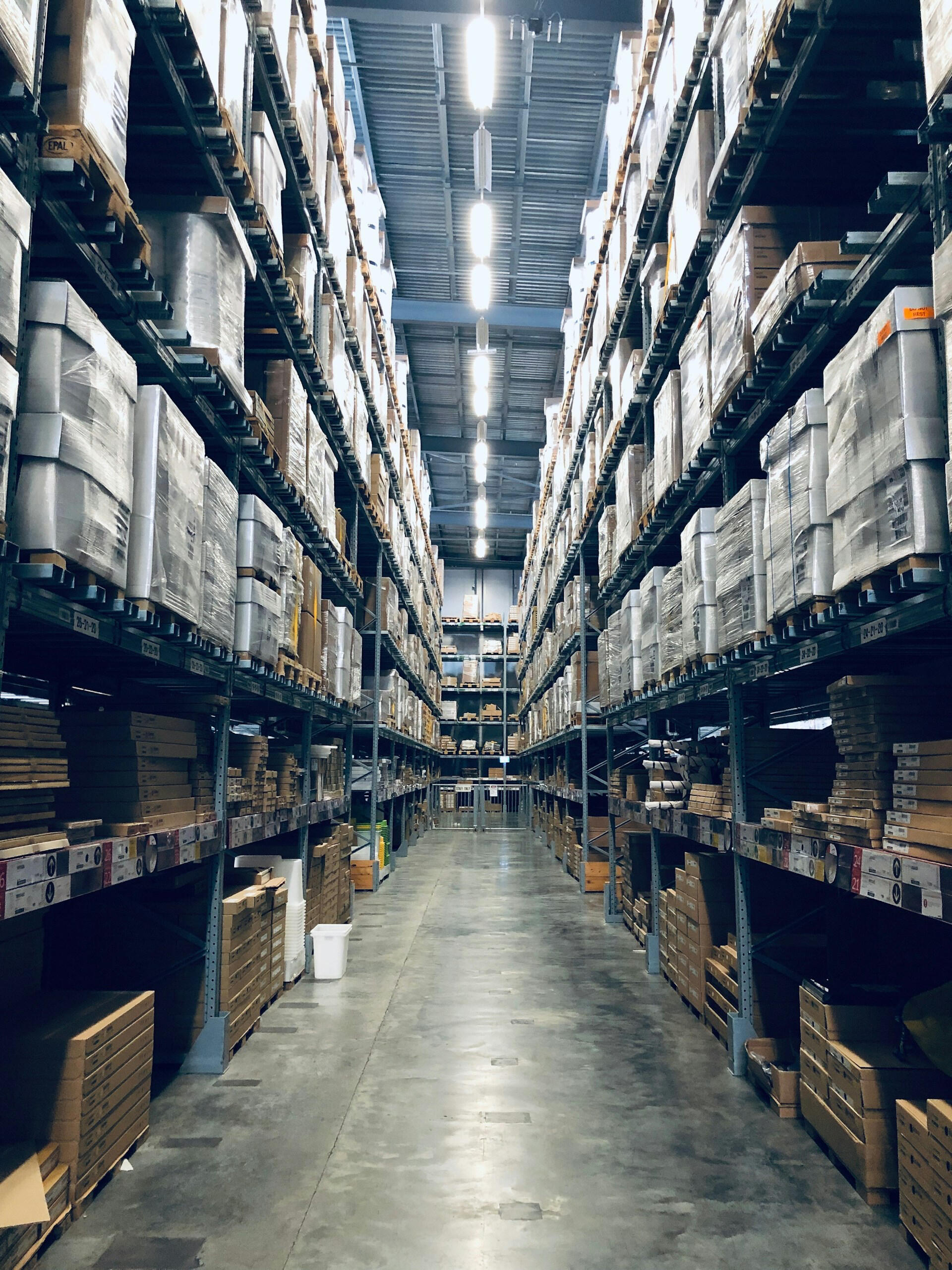 A warehouse aisle stacked with pallets.